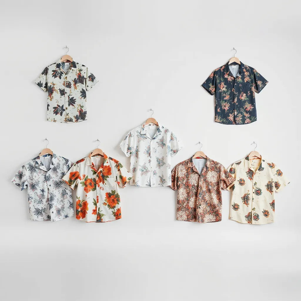 Multiple all-over print shirts on a neutral background showing full-garment patterns